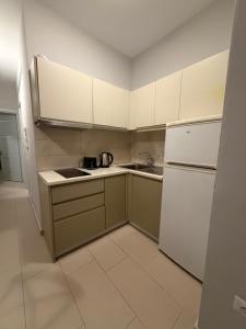 a small kitchen with a sink and a refrigerator at Pool View Private Apartment in Vlorë +12 photos