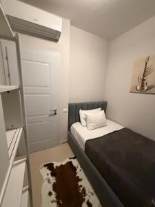 a small bedroom with a bed and a door at Pool View Private Apartment in Vlorë