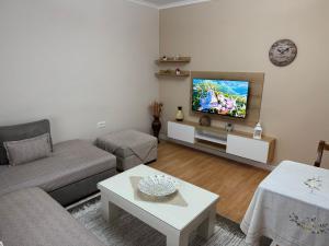 a living room with a couch and a flat screen tv at GRANDPA's HOME in Pusteci