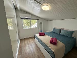 a bedroom with a bed with red slippers on it at Madalena House in Madalena do Mar