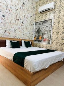a large bed in a bedroom with floral wallpaper at Hotel park view in Bathinda +7 photos