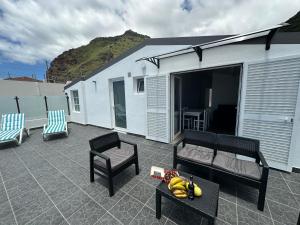 a patio with a couch and a table and chairs at Madalena House in Madalena do Mar