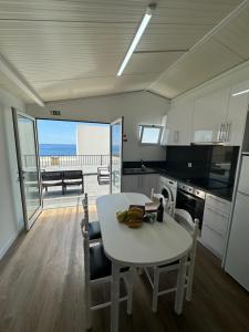 a kitchen with a table and chairs with a view of the ocean at Madalena House in Madalena do Mar