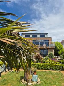a house with a palm tree in front of it at Luxury Apartment Brighton and South Downs National Park, Free Parking, animals on request - daily fee in Brighton & Hove