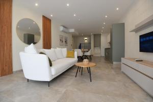 a living room with a white couch and a table at KY Orange Grove in Kerċem