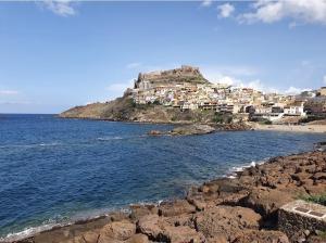 a village on a hill next to the ocean at Casa dei mille in Castelsardo +6 photos