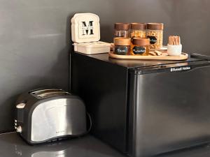 a microwave and a toaster and a clock on top of a refrigerator at Motel M69 in Leicester +12 photos