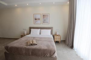 a bedroom with a bed with two shoes on it at KY Orange Grove in Kerċem +50 photos
