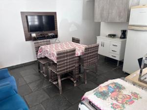 a kitchen with a table and chairs and a television at Casa com 3 quartos in Itu