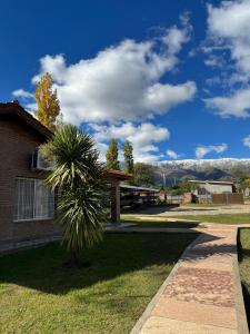 a palm tree in front of a building at El Cantar de los Pajaros in Merlo