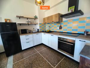 a kitchen with white cabinets and a black refrigerator at Principe - By Turent in Pietra Ligure