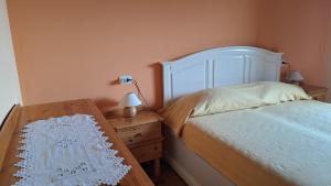 a bedroom with a bed and a table with a lamp at B&B Hannelore in Vilminore