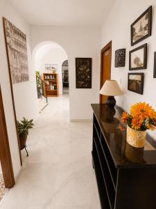 a living room with a black dresser with flowers on it at Hostal Muriel in Aljaraque +55 photos
