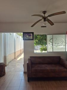 a couch in a living room with a ceiling fan at caribepremiumvalledupar in Valledupar