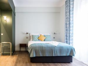 um quarto com uma cama com almofadas azuis e amarelas em 1er Etage SoPi-Montmartre em Paris