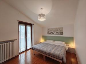 a bedroom with a bed and a large window at Colleoni Lodge CASA VACANZE CON 2 APPARTAMENTI INDIPENDENTI in Verdellino