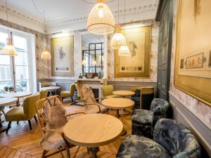 a restaurant with tables and chairs and windows at 1er Etage SoPi-Montmartre in Paris