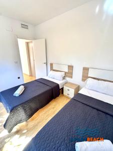 two beds in a hotel room with two beds at APARTBEACH BLAU MAR y PORT AVENTURA in Salou