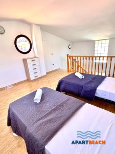 two beds in a room with purple sheets on them at APARTBEACH BLAU MAR y PORT AVENTURA in Salou