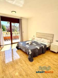a bedroom with a bed and a large window at APARTBEACH BLAU MAR y PORT AVENTURA in Salou