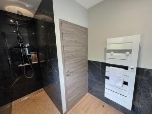 a bathroom with a shower and a glass door at L'Orée Lodge in Montcornet