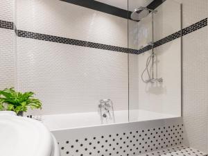a bathroom with a tub and a glass shower at 1er Etage SoPi-Montmartre in Paris