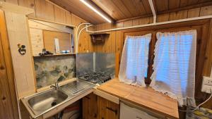 a kitchen with a sink and a stove and a window at Camping Yoghi e Bubu in San Giacomo