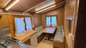 a kitchen with a table and chairs in a cabin at Camping Yoghi e Bubu in San Giacomo