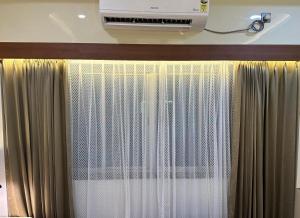a room with a curtain and a air conditioner at Hotel silver star in Kishanganj Bazar
