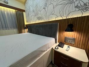 a bedroom with a bed and a phone on a desk at Hotel silver star in Kishanganj Bazar