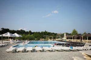 a swimming pool with white lounge chairs and a resort at Serenity in Solotvyno +35 photos