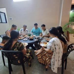 a group of people sitting around a table eating food at Royal Homestay Siliguri in Silīguri Junction