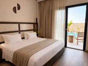 a bedroom with a bed and a balcony with a pool at ABATON Luxury Resort in Tsilivi