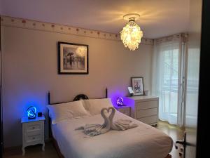 a bedroom with a bed with two swans on it at Hyper centre - Balcon / Parking in Le Havre