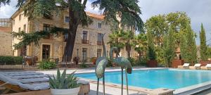 a swimming pool in front of a building at domaine Les Castans in Saint-Thibéry +46 photos