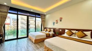 a hotel room with two beds and a large window at Xanh Tốt Hotel - FLC Sầm Sơn in Sầm Sơn +15 photos