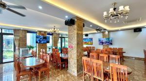a dining room with wooden tables and chairs at Xanh Tốt Hotel - FLC Sầm Sơn in Sầm Sơn