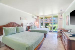 a bedroom with two beds and a desk and a table at Garden Studio | Free Wi-Fi | No Resort Fees in Kapaa +67 photos