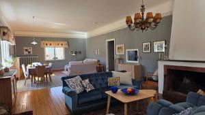 a living room with a blue couch and a table at Bolmen Bed - Vandrarhem in Ljungby