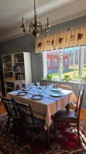 a dining room table with chairs and a tablecloth on it at Bolmen Bed - Vandrarhem in Ljungby