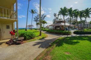 a walkway in front of a resort with palm trees at Garden Studio | Free Wi-Fi | No Resort Fees in Kapaa