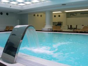 a swimming pool with a waterfall in a building at Melia Madeira Mare in Funchal