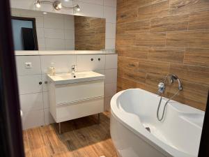 a bathroom with a white tub and a sink at Hotel ZRUČ in Zruč nad Sázavou +19 photos