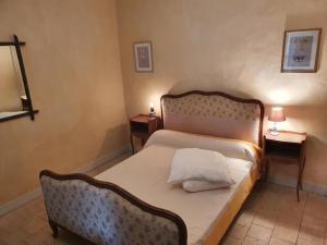 a bedroom with a bed and two night stands with lamps at Ecurie Piaffe & Cie in Lurais +14 photos