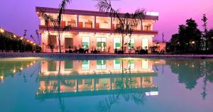 a building with a pool of water in front of it at Foreste Resort in Rāmnagar