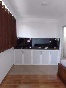 a living room with white cabinets and a large window at Be Cool in Aturugiriya