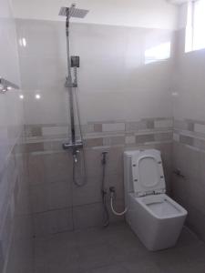 a bathroom with a toilet and a shower in it at Be Cool in Aturugiriya +5 photos