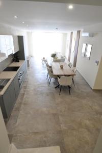 a kitchen and dining room with a table and chairs at KY Orange Grove in Kerċem
