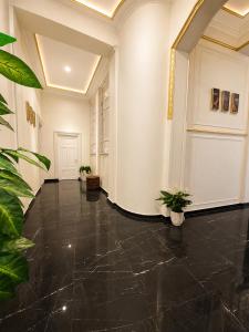 a hallway with black marble floors and white walls at pal ace talaat harb in Cairo