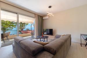 a living room with a large couch and a large window at Pension Alexandros in Preveza